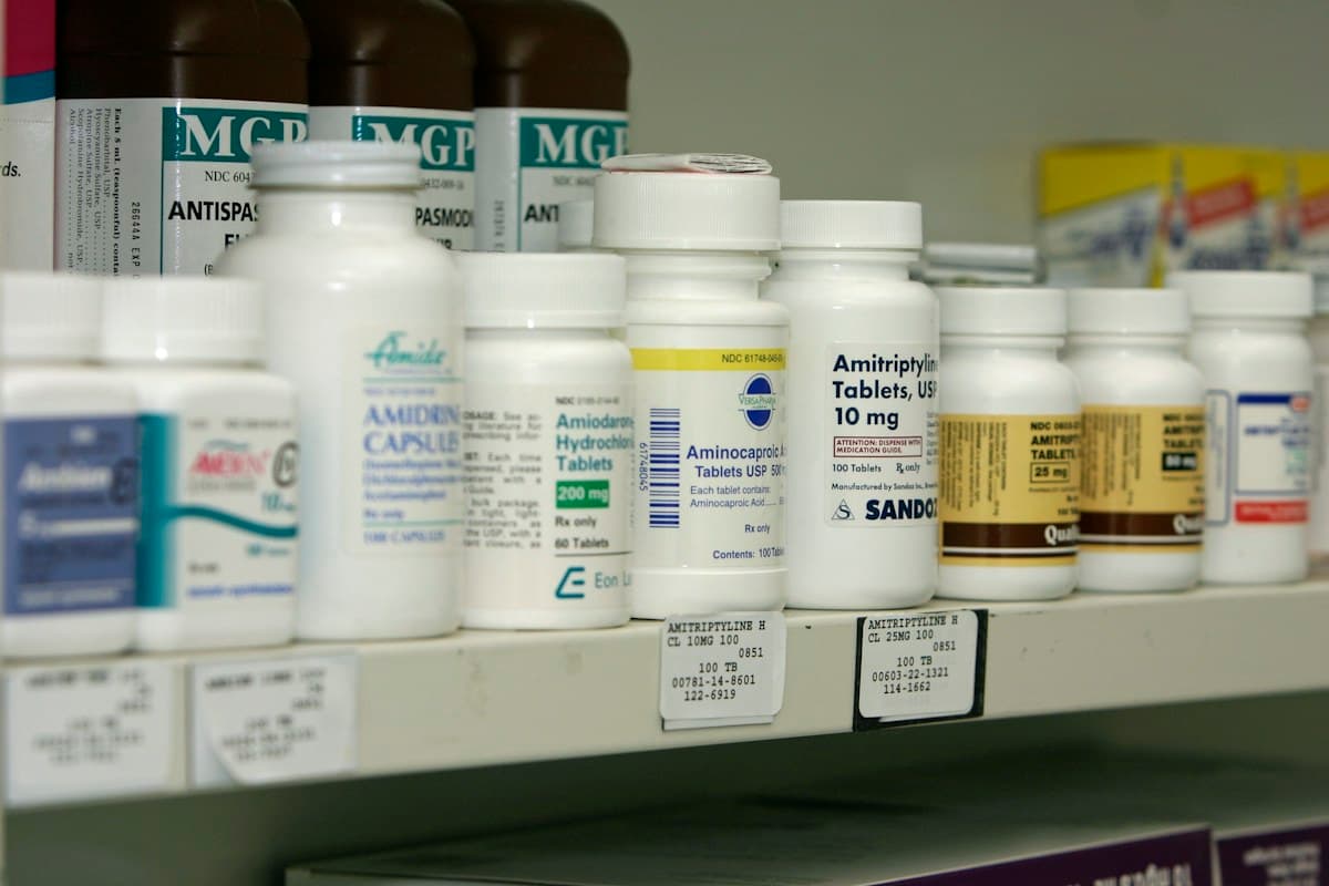 Prescription bottles arranged on a pharmacy shelf.